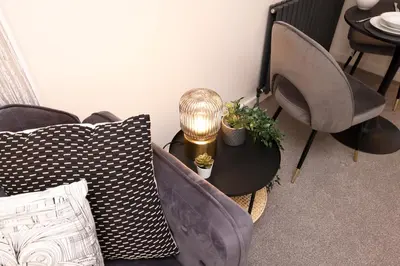 a room with chairs and a table with a lamp at JOIVY Modern 1 bed Flat in West End, close to Princes Gardens in Edinburgh