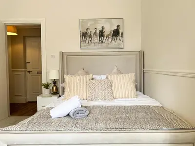 a bedroom with a large bed with pillows at Large Blythswood Residence in Glasgow