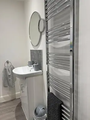 a white bathroom with a sink and a mirror at Cosy Cottage in Stirling