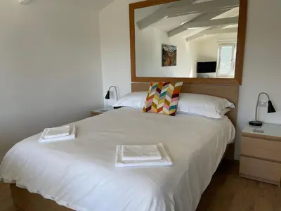 a bedroom with a large white bed with two towels on it at Spacious lodge with king sized bed in Inveraray