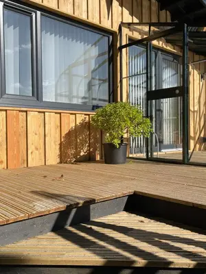 a potted plant sitting on a wooden floor in front of a building at Spacious lodge with king sized bed in Inveraray