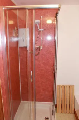 a shower with a glass door in a bathroom at The Barn Lodge in Stirling