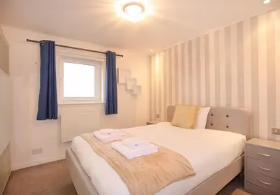 a bedroom with a bed with two towels on it at The South Maybury Residence in Edinburgh