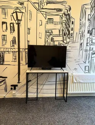 a tv sitting on a table in front of a wall at Central Glasgow Apt - Sleeps 2 & FreeParking During Weekend in Glasgow