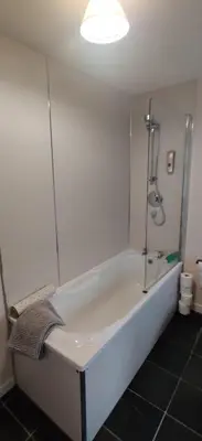 a white bath tub in a bathroom with a shower at The Cobbler Cottage - Loch Lomond and Arrochar Alps in Arrochar