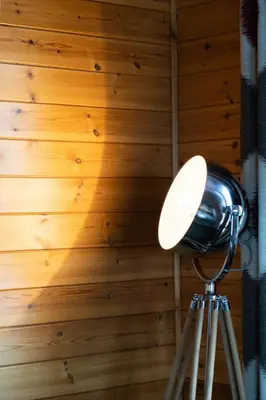 a lamp on a tripod next to a wooden wall at Chalet Loch Leven Lodge 12 by Interhome in Kinross