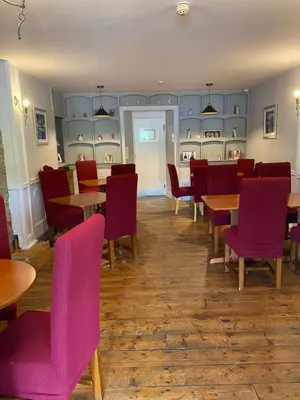 a dining room with tables and chairs and purple chairs at West Loch House in West Tarbert