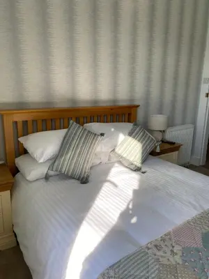 a bed with two pillows on top of it at West Loch House in West Tarbert