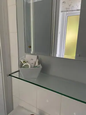 a glass shelf in a bathroom with a mirror at West Loch House in West Tarbert
