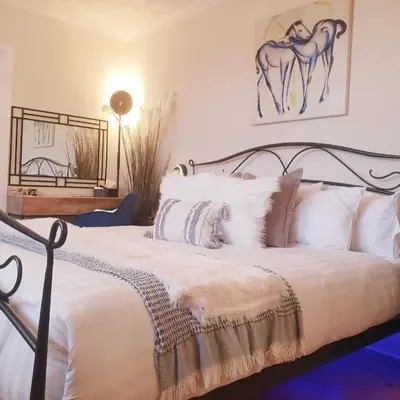a bedroom with a bed with white sheets and pillows at The NEW Blue Horse Suite at The Grumpy Schnauzer B&B Luxury Private Indoor Hot Tub Breakfast in Bed in Airdrie