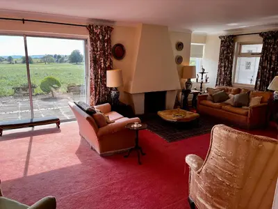 a living room with couches and a fireplace at Whitehouse in Uplawmoor