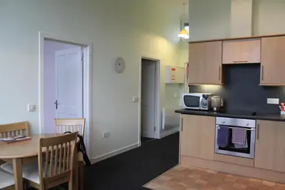 a small kitchen with a table and a microwave at The Old School in Dalavich