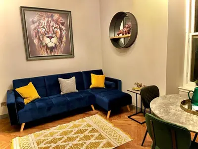 a living room with a blue couch and a table at 1 bed Apt in West End in Glasgow