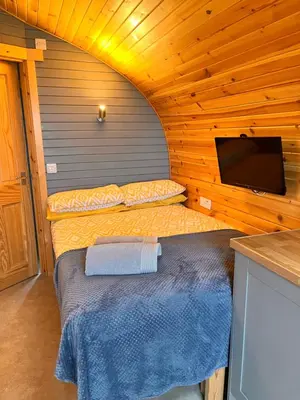 a bedroom with a bed and a tv in a cabin at Sea Breeze Pod in Fort William