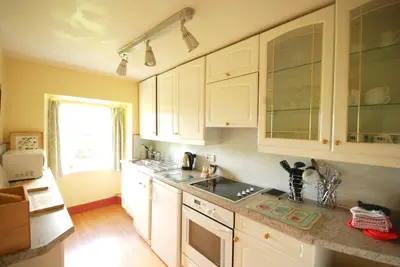 a kitchen with white cabinets and a sink at Bonawe House Holiday Cottages in Taynuilt