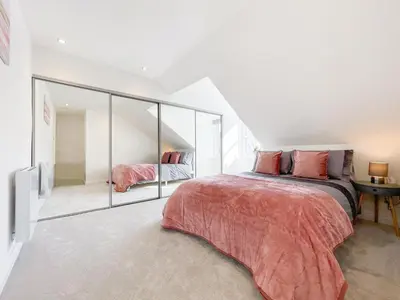a bedroom with a bed and a mirror at The Penthouse in Oban