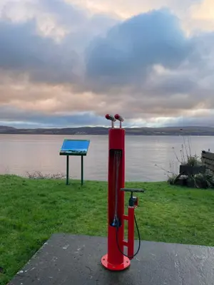 a red fire hydrant with birds perched on it next to the water at Dunoon River Clyde Flat in Innellan