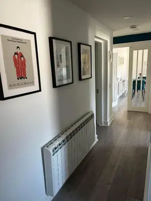 a hallway with a radiator and pictures on the wall at Entire Modern Apartment in Oban with Balcony in Oban