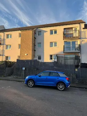 a blue car parked in front of a fence at Entire Modern Apartment in Oban with Balcony in Oban