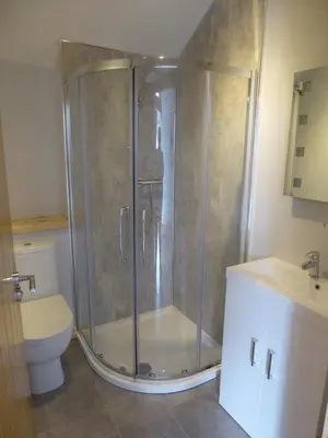 a bathroom with a shower and a toilet at Auchendennan Farm Self Catering Cottages in Balloch