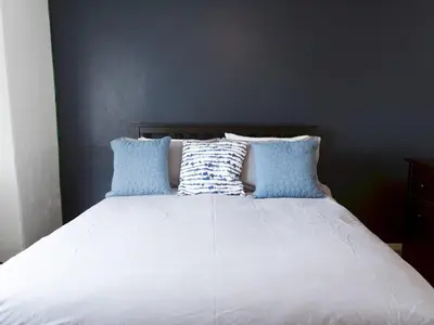 a bed with blue and white pillows on it at Cozy two bed flat near Glasgow Airport & Paisley - Pass the Keys in Paisley