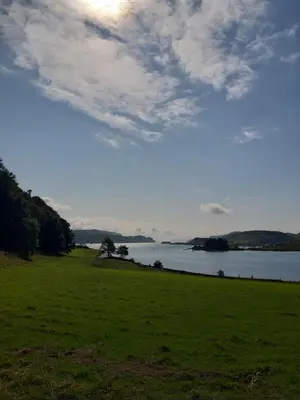 a grassy field with a large body of water at Pier View Apartment in Oban