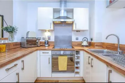 a kitchen with white cabinets and a stove top oven at Oswald Apartment - Glasgow City Centre in Glasgow