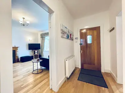 a room with a hallway with a door and a table at Millerston House in Glasgow