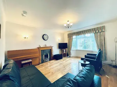 a living room with a couch and a piano at Millerston House in Glasgow