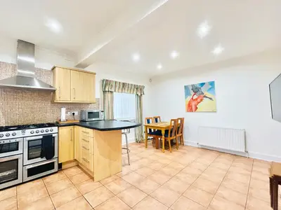 an open kitchen and dining room with a table and chairs at Millerston House in Glasgow