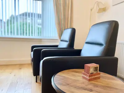 two black chairs and a table in a room at Millerston House in Glasgow