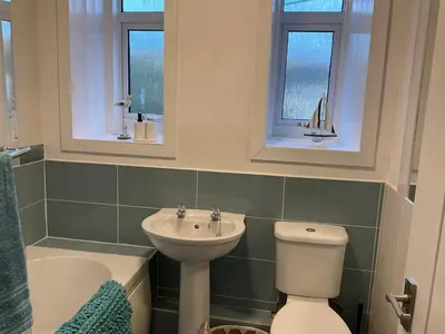 a bathroom with a sink and a toilet and two windows at Glenashdale 28 A 1/R Boyd Street Largs KA308LE in Largs