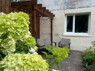 two chairs sitting under a pergola in a garden at The Mews with Private Parking in Oban