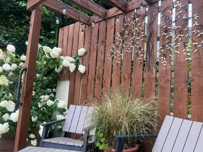 a wooden fence with two benches and flowers at The Mews with Private Parking in Oban