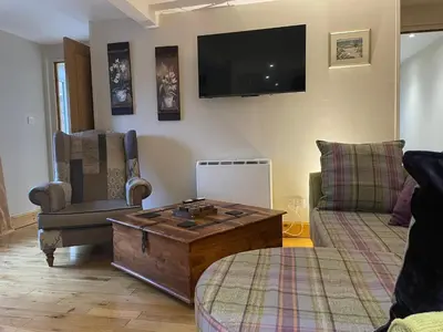 a living room with a coffee table and a tv at The Mews with Private Parking in Oban