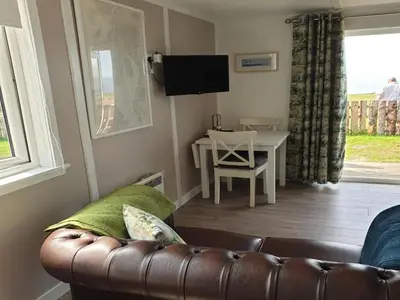 a living room with a leather couch and a table at North Muasdale Farm in Muasdale