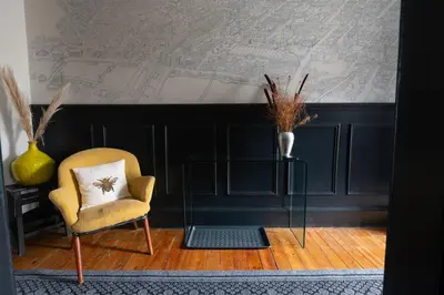 a room with a chair and a map on the wall at Traditional apt close to city centre & Hampden in Glasgow