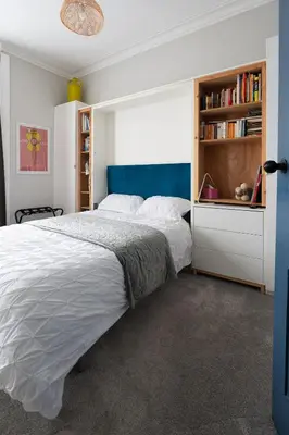 a bedroom with a large bed and a book shelf at Traditional apt close to city centre & Hampden in Glasgow