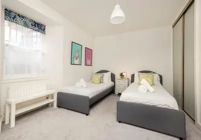 a bedroom with two beds and a window at The Old Bakery in Edinburgh