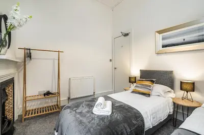 a bedroom with a bed and a fireplace at Renfrew Residence Central Glasgow 4-Bed Flat in Glasgow