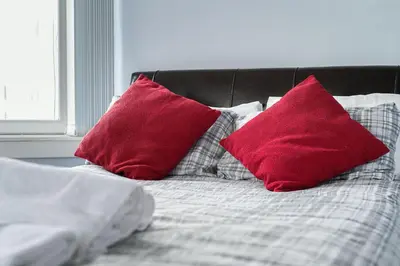 two red pillows sitting on top of a bed at amazing apartments - Torphichen Place by Haymarket in Edinburgh