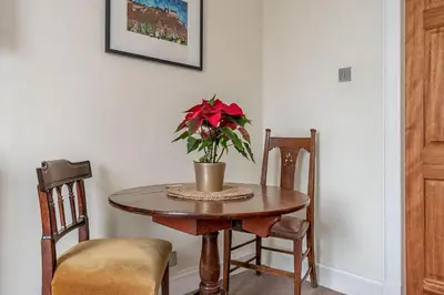 a table with a vase with a red flower on it at amazing apartments - Torphichen Place by Haymarket in Edinburgh