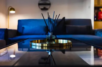 a living room with a table with a blue couch at The Skyline Suite - *Private Balcony* *Views* in Glasgow