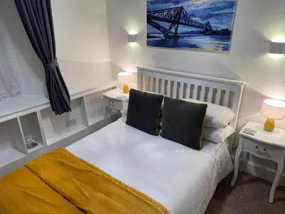 a small bedroom with a bed with two night stands at Heart of George street / Oban / Argyll in Oban