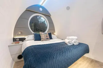 a bedroom with a bed with a round window at The Secret Hideaway in Penicuik