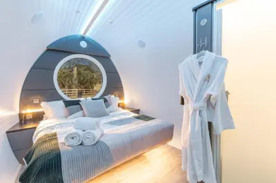 a bedroom with a bed with a round window at The Secret Hideaway in Penicuik