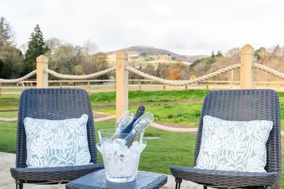 two chairs and a table with a glass of water at The Secret Hideaway in Penicuik