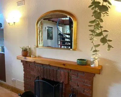 a living room with a fireplace with a mirror at Wee Silverburn in Whiting Bay