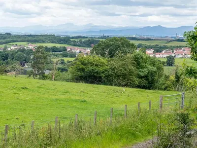 a field of green grass with a fence in it at Alban in Linlithgow