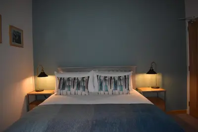 a bedroom with a large bed with two night stands at Orchy Bank House in Dalmally